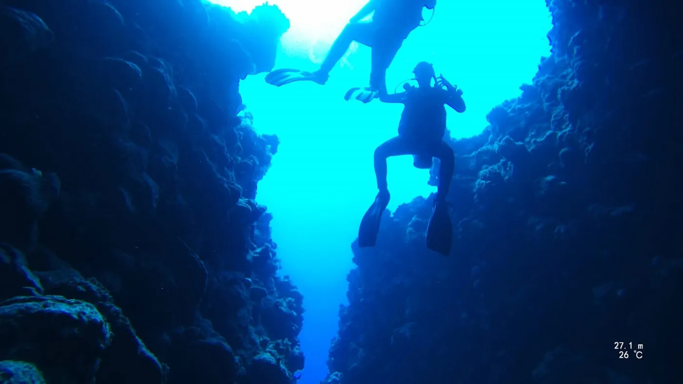 Inside the Canyon at Dahab: a diver in the narrow fissure at twenty seven metres, with daylight in the slot above